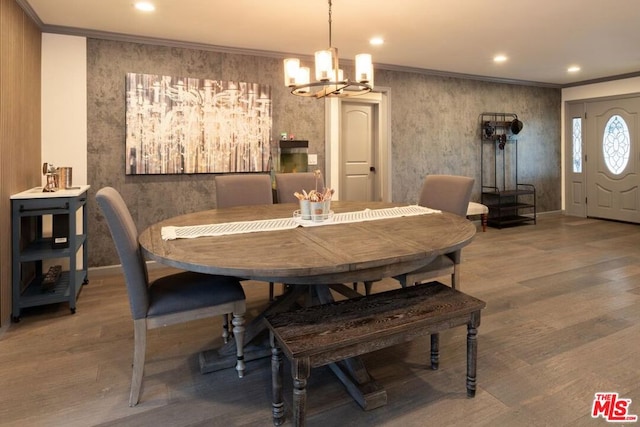 dining space featuring crown molding, a chandelier, and hardwood / wood-style floors