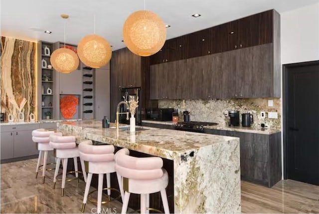 kitchen featuring hanging light fixtures, dark brown cabinets, and a breakfast bar area