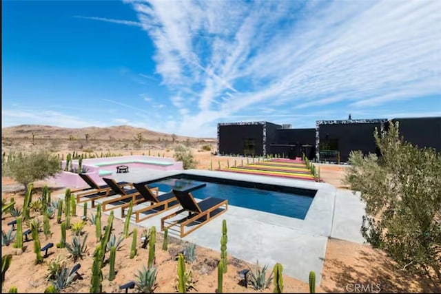 view of swimming pool with a mountain view and a patio