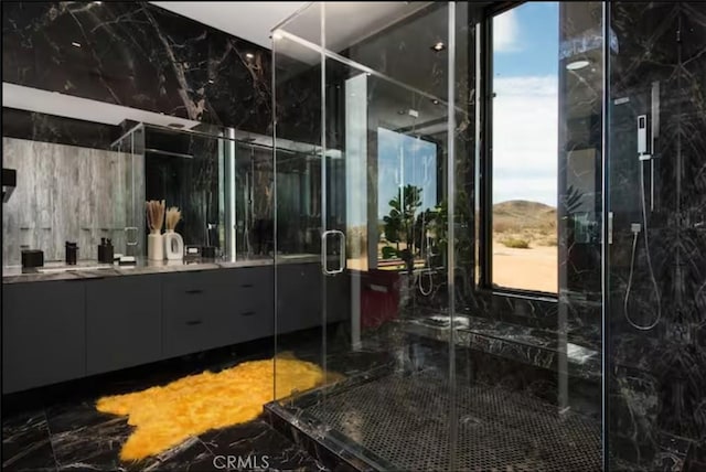 bathroom with vanity and a shower with door