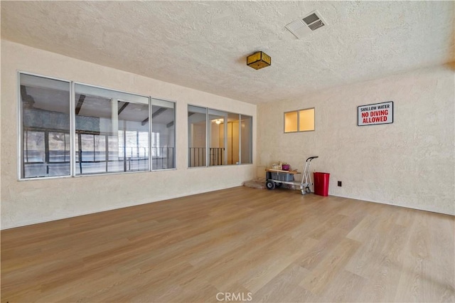 spare room featuring hardwood / wood-style flooring and a textured ceiling