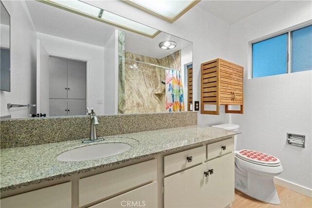 626 Westlake Dr, Palmdale, CA 93551 - full bath with wood finished floors, toilet, vanity, baseboards, and curtained shower