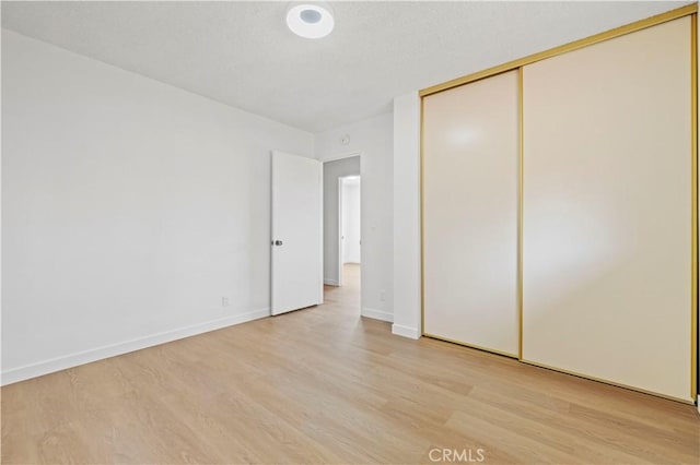 unfurnished bedroom with light hardwood / wood-style floors and a closet