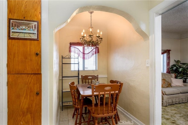 tiled dining space featuring an inviting chandelier