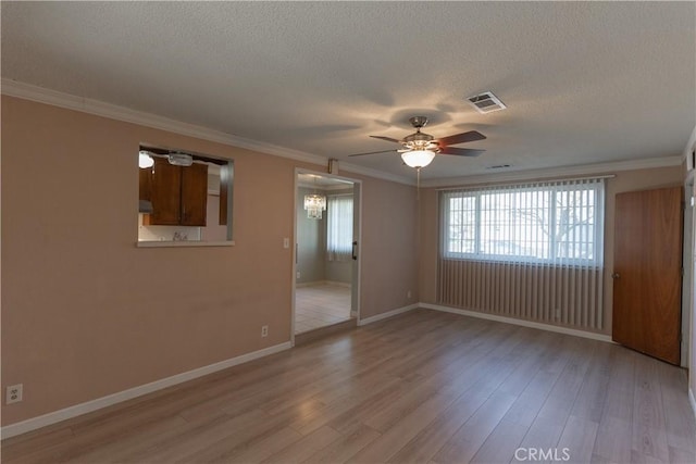 unfurnished room featuring a textured ceiling, visible vents, baseboards, light wood finished floors, and crown molding