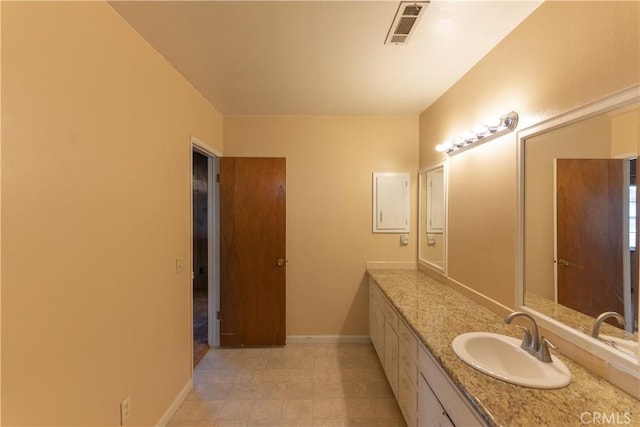 bathroom with baseboards, visible vents, and vanity