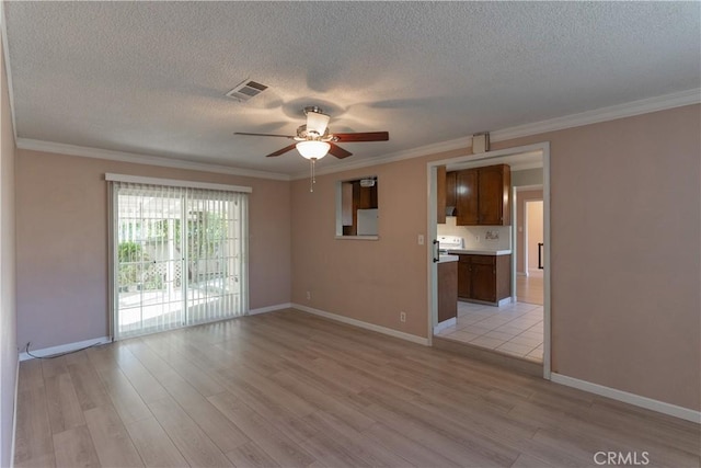 unfurnished room featuring visible vents, light wood-style flooring, ornamental molding, a ceiling fan, and baseboards