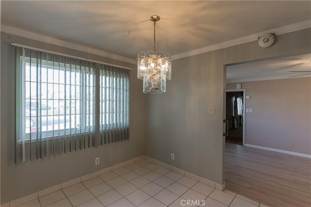 empty room with a chandelier, crown molding, baseboards, and light tile patterned floors