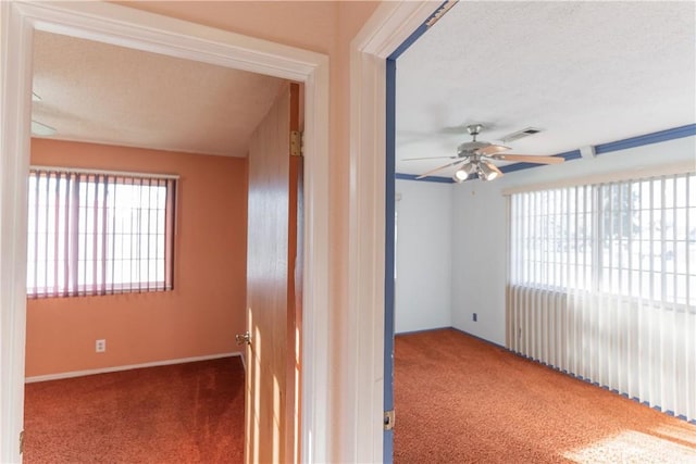 spare room with ceiling fan, visible vents, and carpet flooring