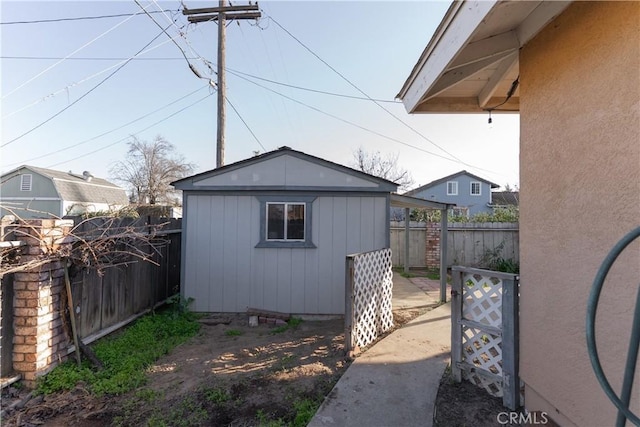 view of home's exterior featuring a fenced backyard, a shed, and an outbuilding