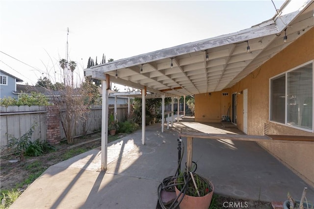 view of patio / terrace featuring a carport and a fenced backyard