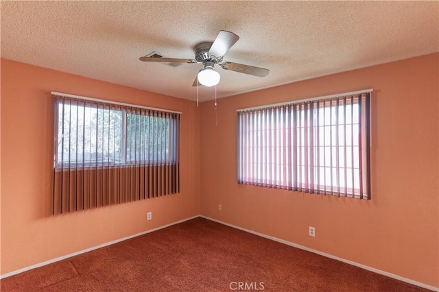 carpeted spare room featuring ceiling fan, baseboards, and a textured ceiling