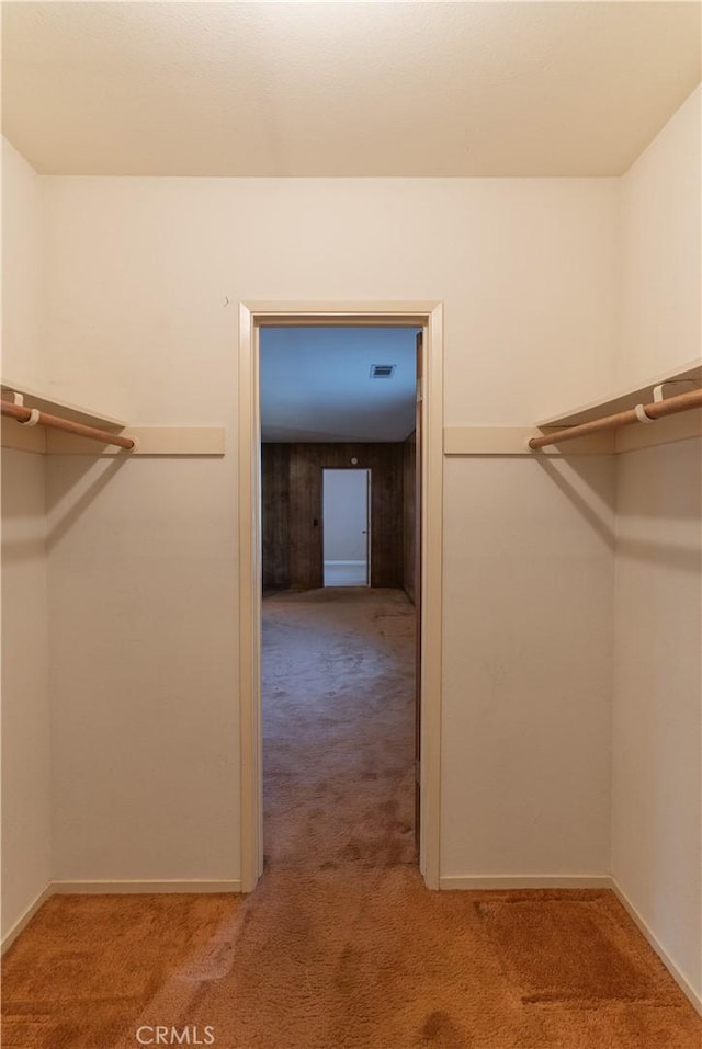 walk in closet with visible vents and light colored carpet