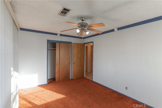 unfurnished bedroom with a closet, light colored carpet, visible vents, ornamental molding, and a textured ceiling