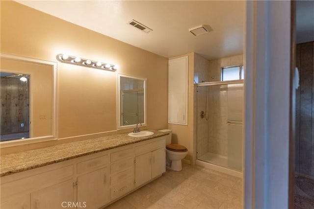 bathroom featuring toilet, a stall shower, vanity, and visible vents