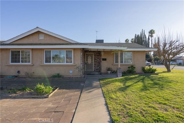 ranch-style house featuring a front yard and stucco siding