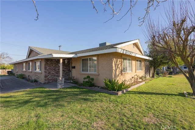 ranch-style house featuring a front yard and stucco siding