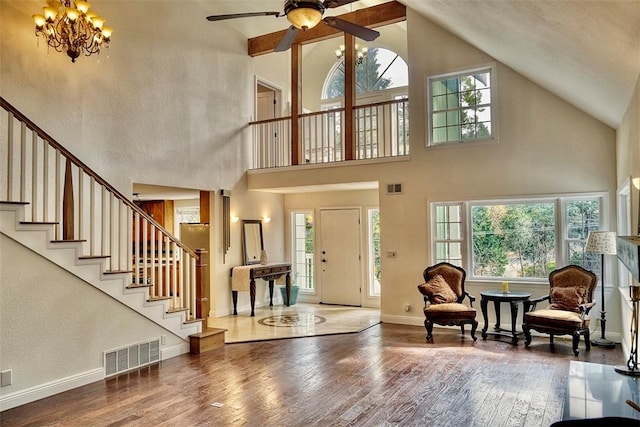 foyer with a towering ceiling, hardwood / wood-style floors, and a notable chandelier