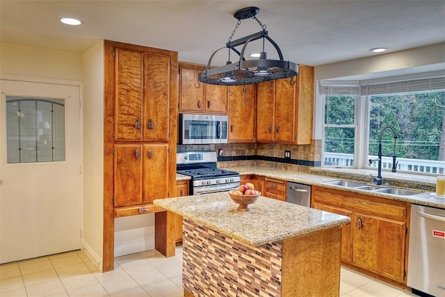 kitchen with appliances with stainless steel finishes, sink, hanging light fixtures, a center island, and light tile patterned floors