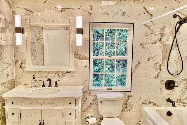 full bathroom with  shower combination, toilet, vanity, and tile walls