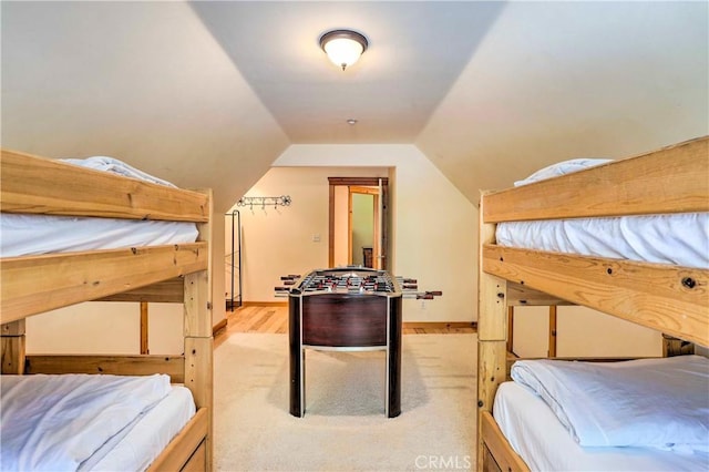 bedroom featuring lofted ceiling and light colored carpet