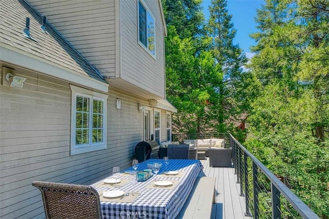 wooden terrace featuring an outdoor living space and area for grilling