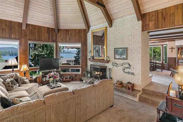 living room featuring wood walls, lofted ceiling with beams, light carpet, wooden ceiling, and a brick fireplace