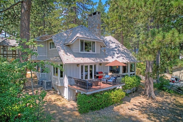 back of house featuring cooling unit and a deck