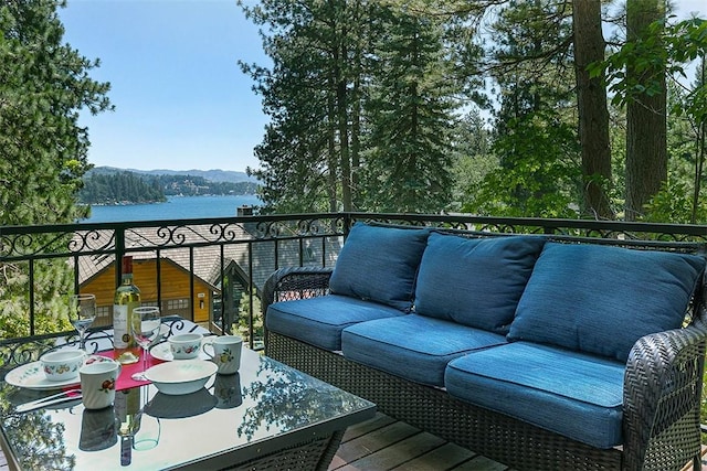 balcony with outdoor lounge area and a water view