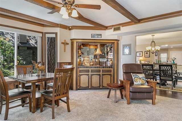 carpeted dining room with ceiling fan with notable chandelier and beam ceiling