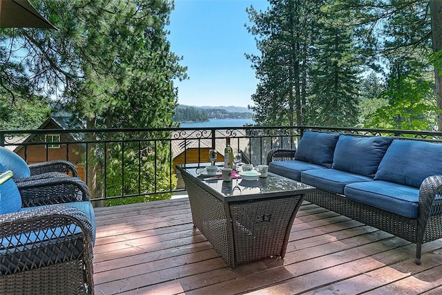 wooden terrace featuring an outdoor living space and a water view