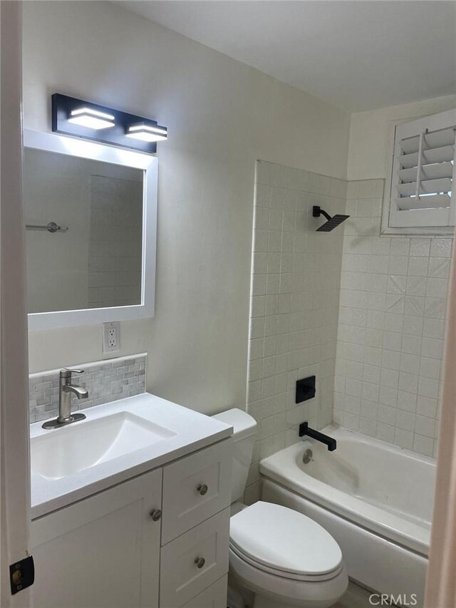 full bathroom featuring tiled shower / bath combo, vanity, toilet, and decorative backsplash