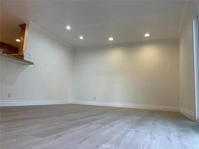 unfurnished room with ornamental molding and light wood-type flooring