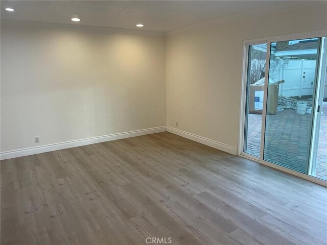 spare room featuring hardwood / wood-style flooring and crown molding