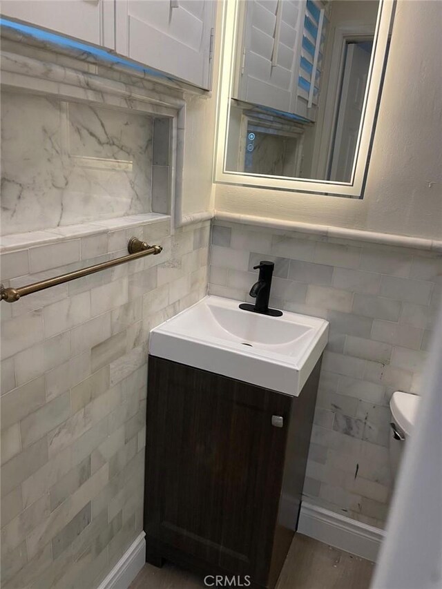 bathroom featuring vanity and tile walls