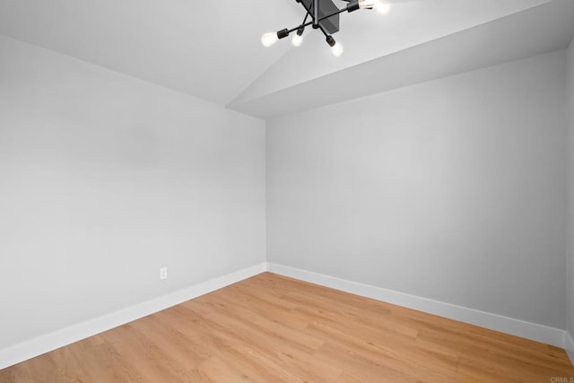 empty room with hardwood / wood-style flooring and lofted ceiling