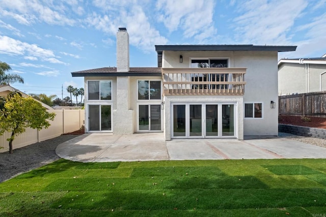 back of house with a balcony, a yard, and a patio