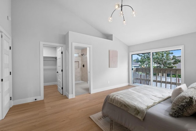 bedroom featuring high vaulted ceiling, ensuite bath, light wood-type flooring, a spacious closet, and an inviting chandelier