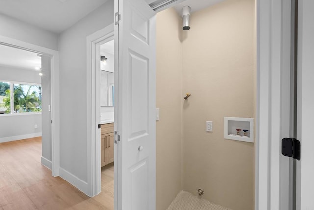 clothes washing area featuring washer hookup and light hardwood / wood-style flooring