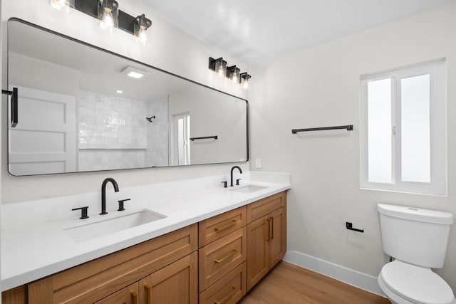 bathroom with hardwood / wood-style flooring, a shower, vanity, and toilet