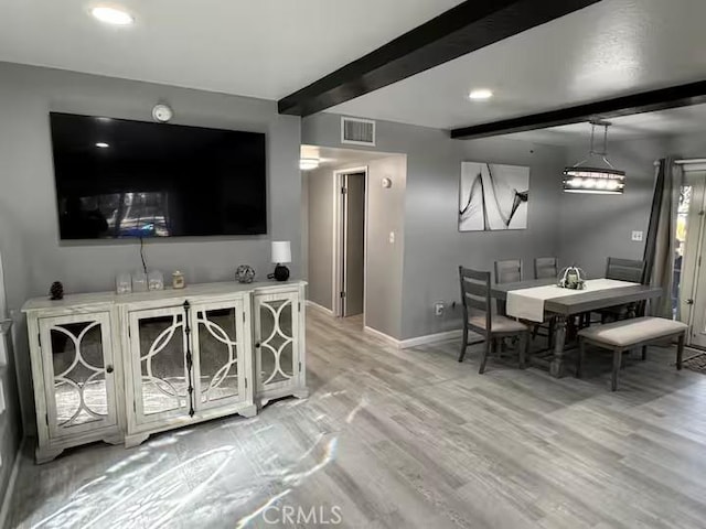 interior space with beam ceiling and light hardwood / wood-style flooring