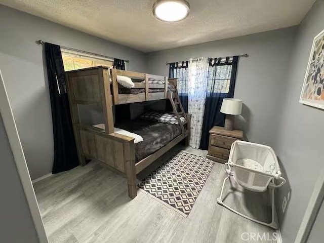 bedroom featuring a textured ceiling and light hardwood / wood-style flooring