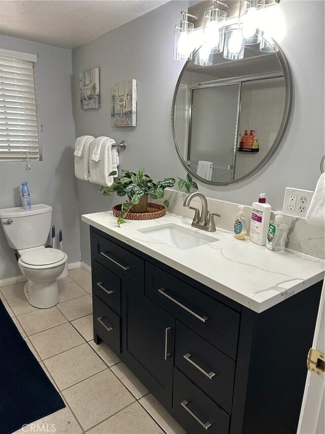 bathroom with walk in shower, vanity, toilet, and tile patterned flooring