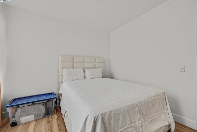 bedroom with wood-type flooring and crown molding