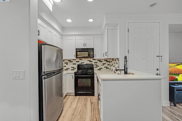 kitchen featuring white cabinetry, backsplash, light hardwood / wood-style floors, and black appliances