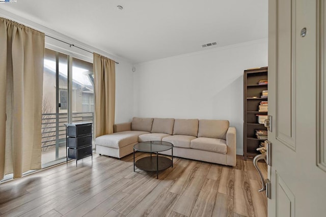 living room featuring ornamental molding and light hardwood / wood-style floors