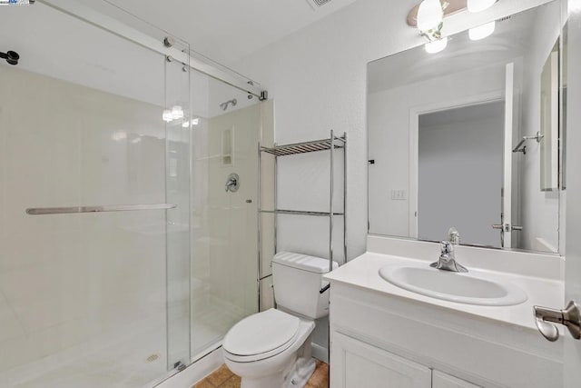 bathroom featuring toilet, vanity, and walk in shower