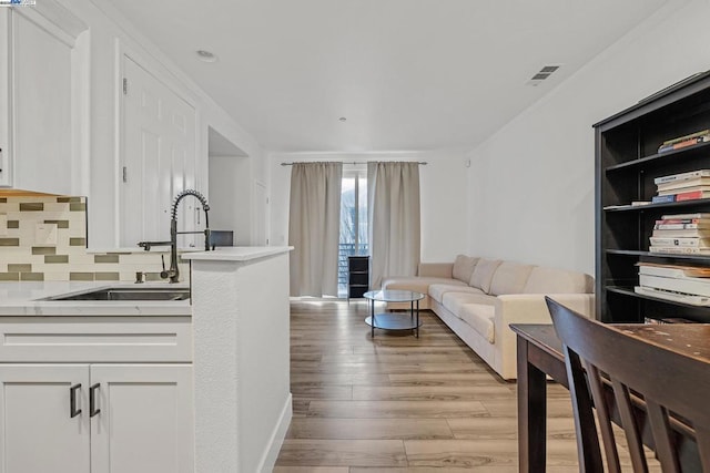 living room with sink and light hardwood / wood-style flooring