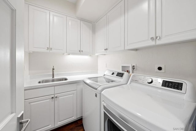 laundry area with cabinets, independent washer and dryer, and sink