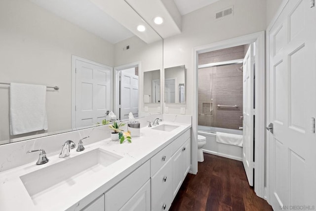 full bathroom with enclosed tub / shower combo, wood-type flooring, vanity, and toilet